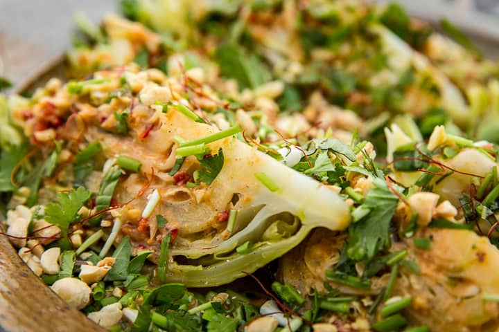 Coal Roasted Cabbage with Spicy Peanut Vinaigrette and topped with dried chile thread and mint oil