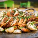 Deboned Whole Chicken carved into roulades and fanned out across grilled carrots and turnips, drizzled with a reduced chicken stock and sprinkled with fresh herbs.