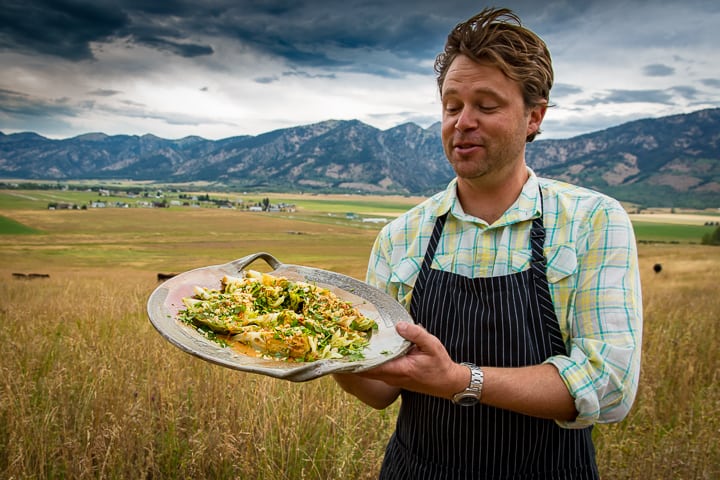 Chef Eric Wilson holding the Coal Roasted Cabbage with Spicy Peanut Vinaigrette
