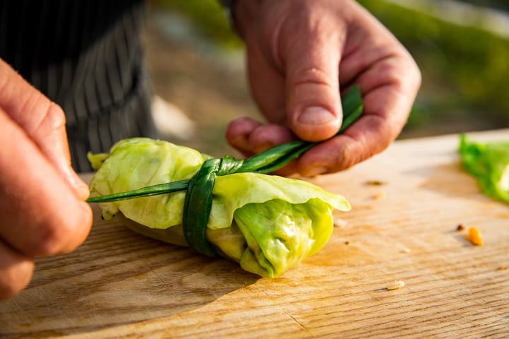 Pulling the green onion knot tight on the Chorizo Stuffed Cabbage parcels