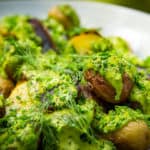 A platter full of salt roasted potatoes drizzled with a vibrant green goddess dressing and garnished with finely chopped chives and hand torn dill sprigs