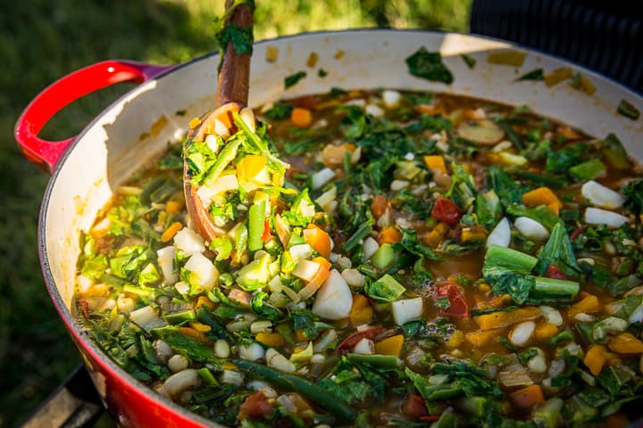 Stirring the escarole greens into the garden vegetable minestrone soup