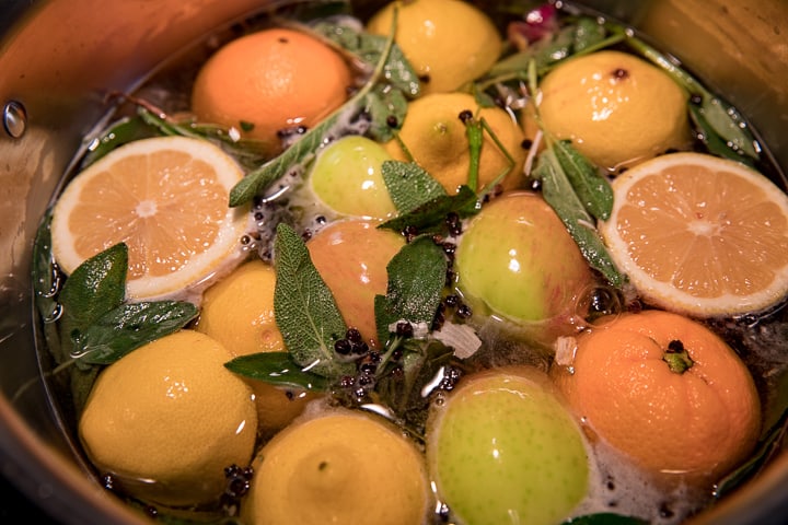 Wood Fired Sous Vide Turkey Brine in a stock pot loads of lemons, an orange, apple fresh herbs peppercorns, salt