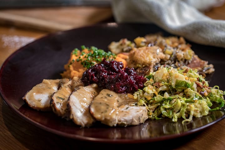 Wood Fired Thanksgiving plated up with piles of turkey, cranberry, brussels sprouts, stuffing and yams